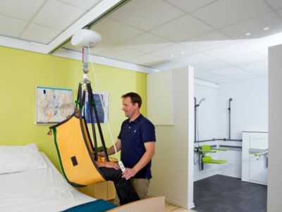 plafondlift systeem met rails aan plafond in zorgomgeving