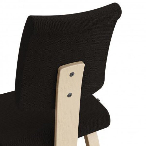Close-up van de rugleuning van de Varier Variable Plus balansstoel met zwarte bekleding en licht houten frame