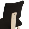 Close-up van de rugleuning van de Varier Variable Plus balansstoel met zwarte bekleding en licht houten frame